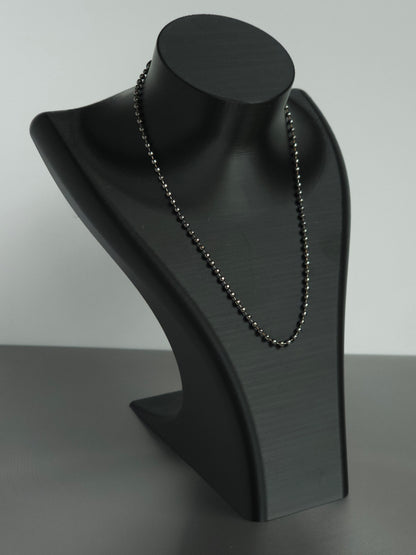 A stock Sniff and Slide bump straw necklace, with black beaded chain necklace displayed on a matte black jewelry bust against a light gray background.