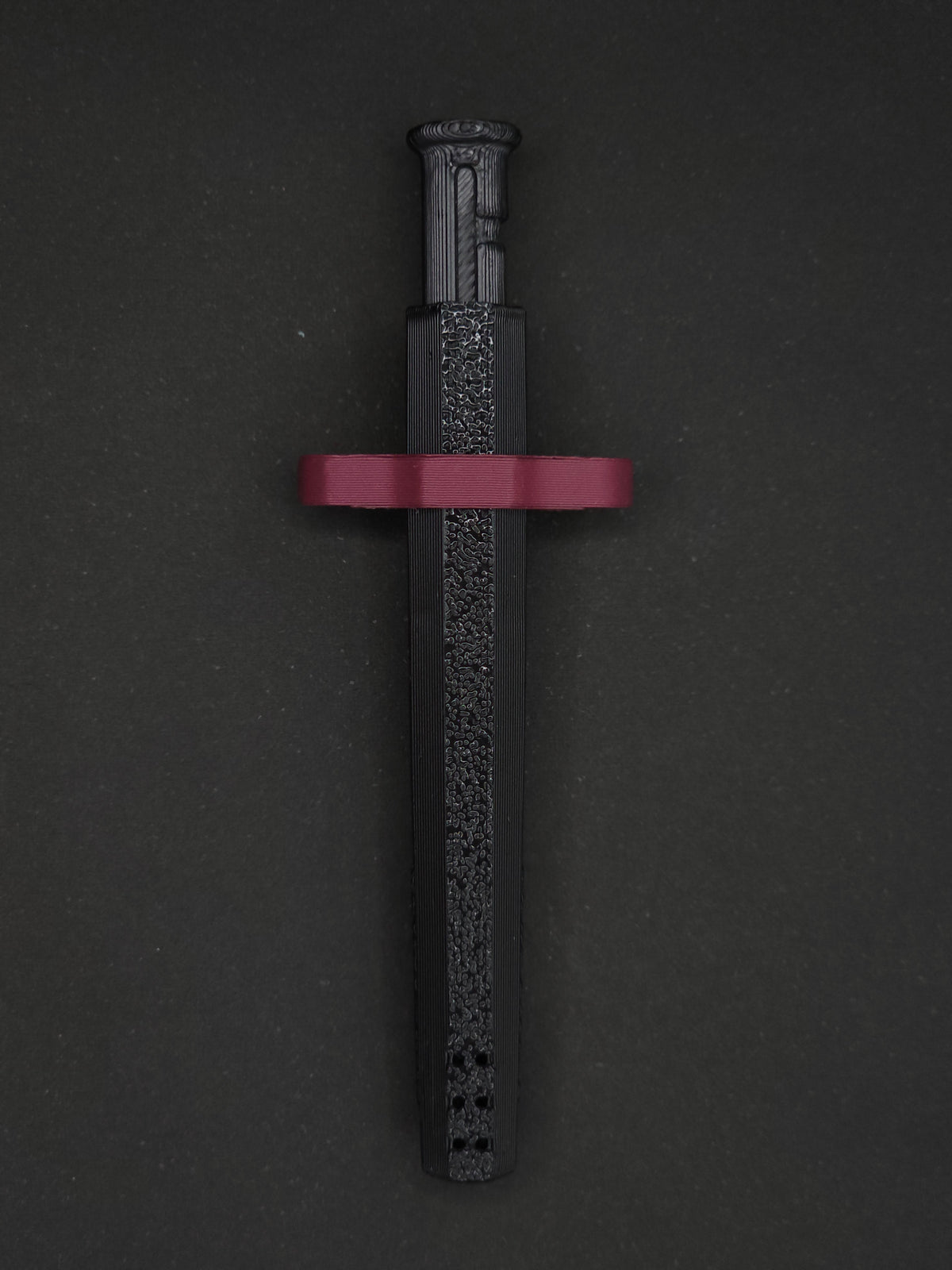 Burgundy necklace adapter on a Black Sniff & Slide spring-loaded bump straw necklace, dark gray background.