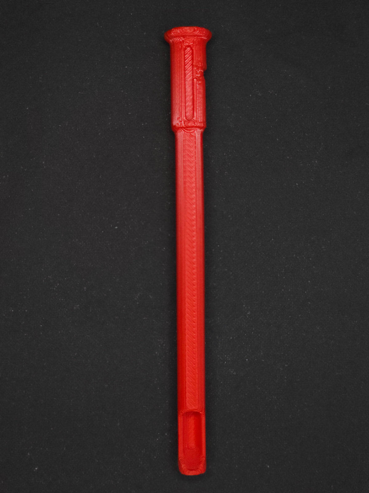 A red textured plastic straw scoop insert accessory, shown vertically on a dark gray background.