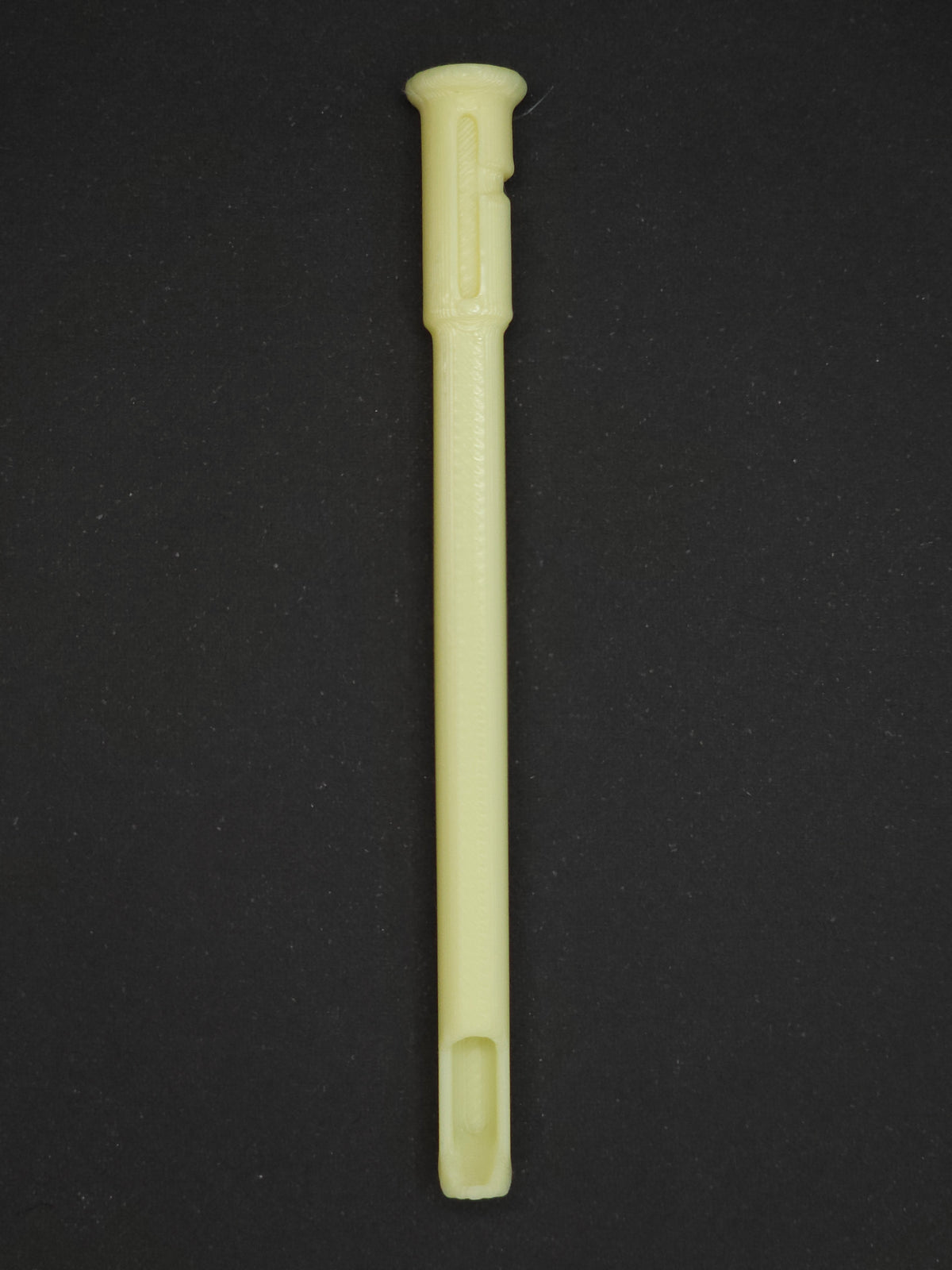 A pale yellow textured plastic straw scoop insert accessory, shown vertically on a dark gray background.
