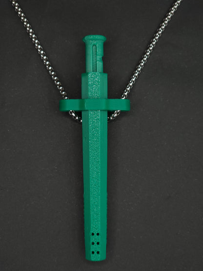 A green spring-loaded bump straw pendant on a silver box chain, displayed against a dark textured background