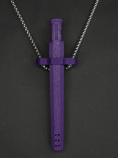 A purple spring-loaded bump straw pendant on a silver box chain, displayed against a dark textured background