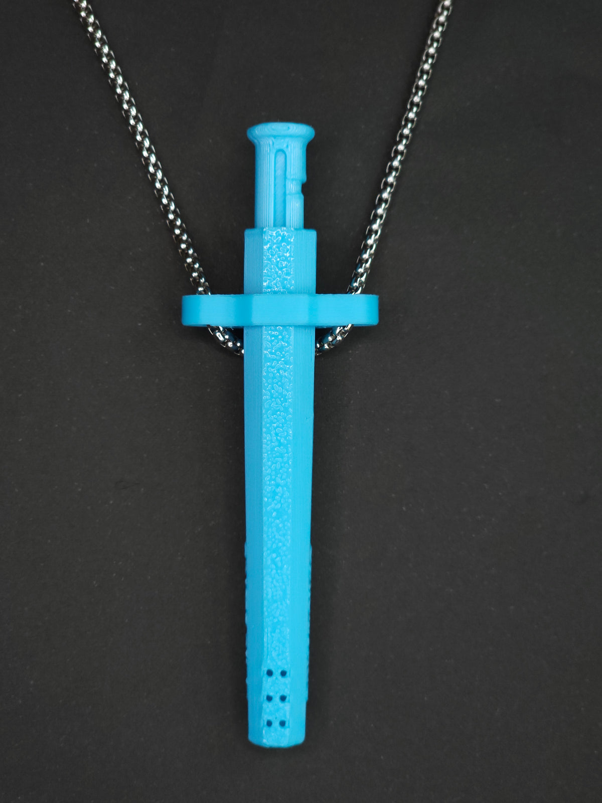 A sky blue spring-loaded bump straw pendant on a silver box chain, displayed against a dark textured background