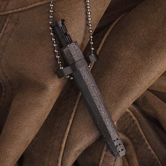 Sniff & Slide spring-loaded dispenser pendant in Black, with silver ball chain, displayed on brown leather