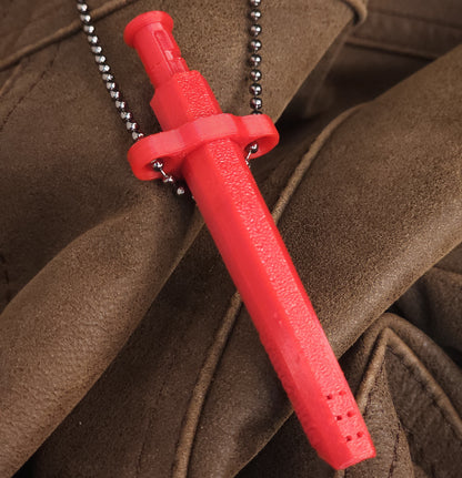 A bright red Sniff & Slide bump straw necklace with textured grip and silver ball chain, displayed on folded brown leather