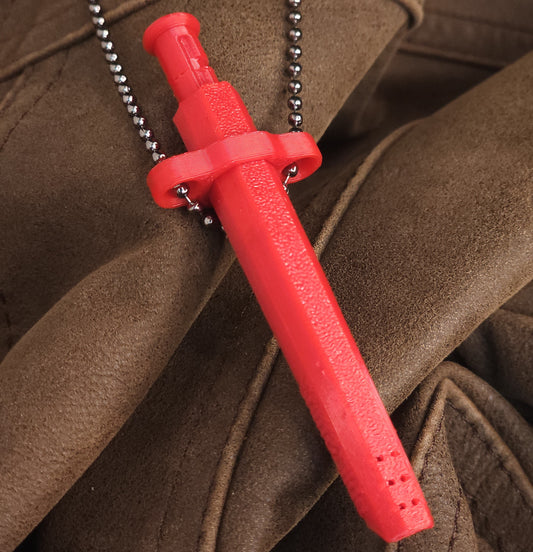 A bright red Sniff & Slide bump straw necklace with textured grip and silver ball chain, displayed on folded brown leather