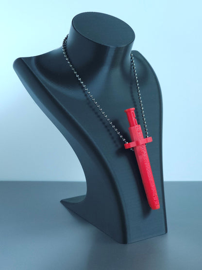 Sniff & Slide spring-loaded dispenser pendant in a vibrant Red with silver ball chain, displayed on black mannequin bust, over a white and grey background